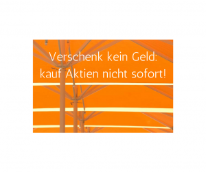 Auf dem Bild sind gelbe Regenschirme zu sehen. Der Text lautet: Verschenk kein Geld: kauf Aktien nicht sofort!