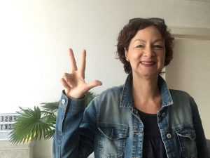 Auf dem Bild sieht du eine lachende Frau, die 3 Finger hochhält. Der Bildtext lautet: 3 Faktoren für deinen Börseneinstieg mit ETFs